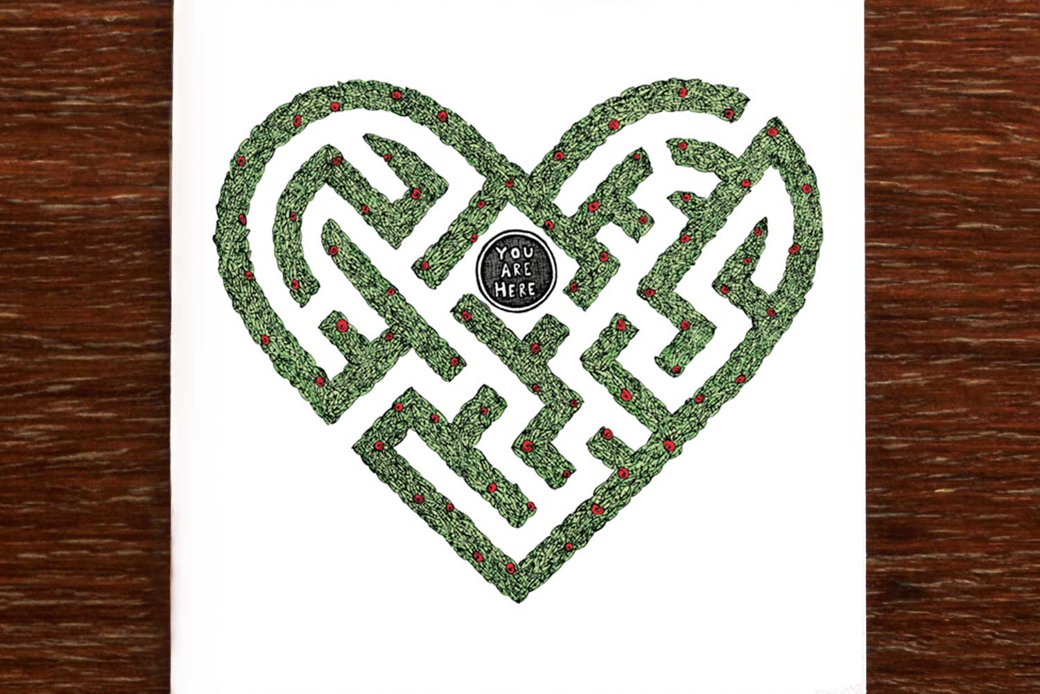 Greeting card with a heart shaped hedge maze and the words "You are here" in the centre.