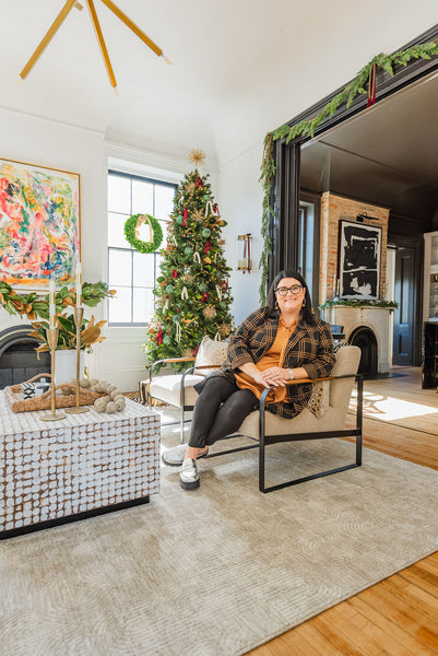 Modern coastal black and white christmas living room with katrina Morris sitting in a chaire
