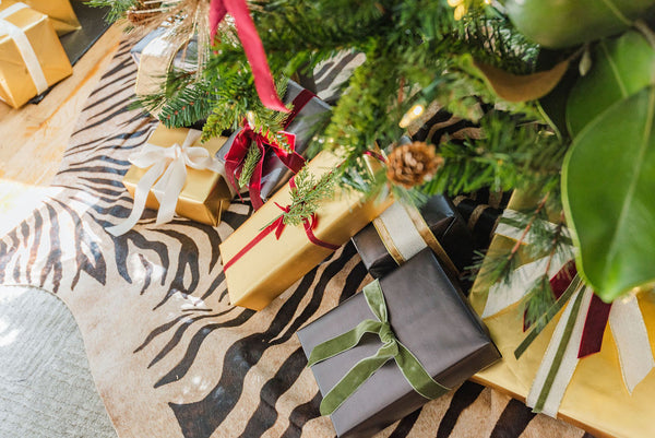black and golde luxury chrostmas present under the tree tied with velvet ribbon form Katrina and co