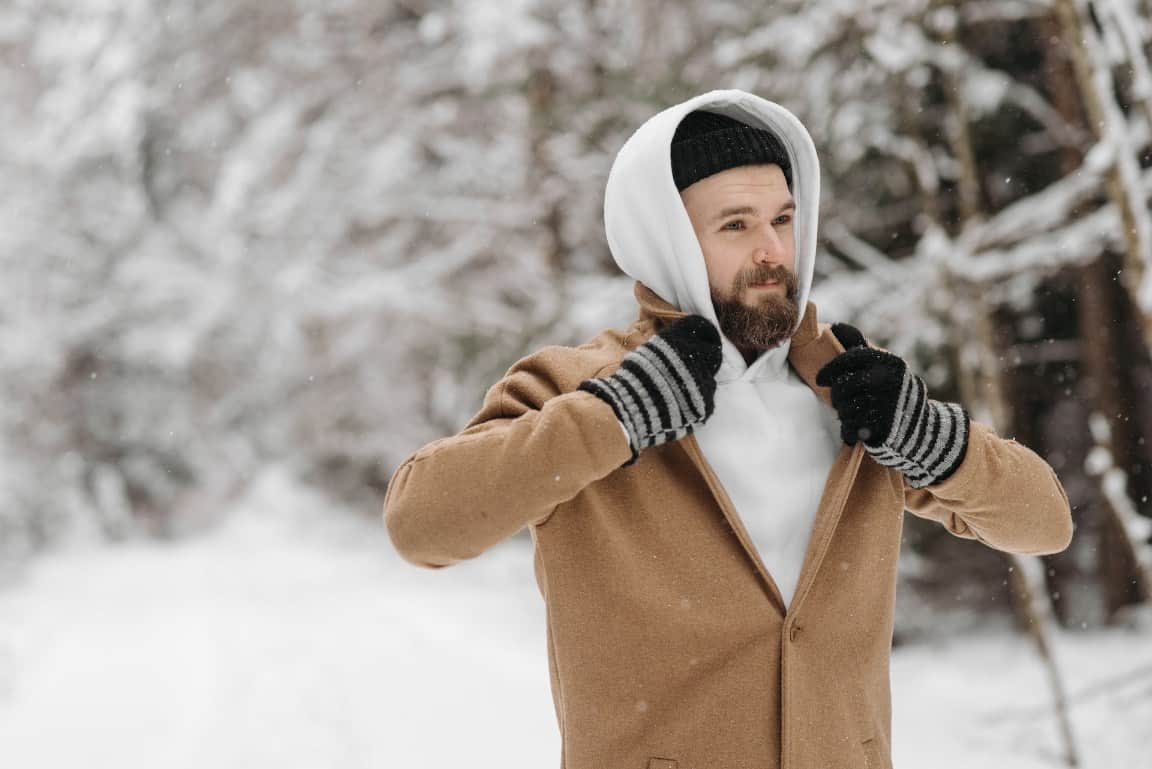 Tinuta de iarna pentru barbati si cele 3 stiluri fashion principale - palton maro, hanorac alb, manusi cu dungi