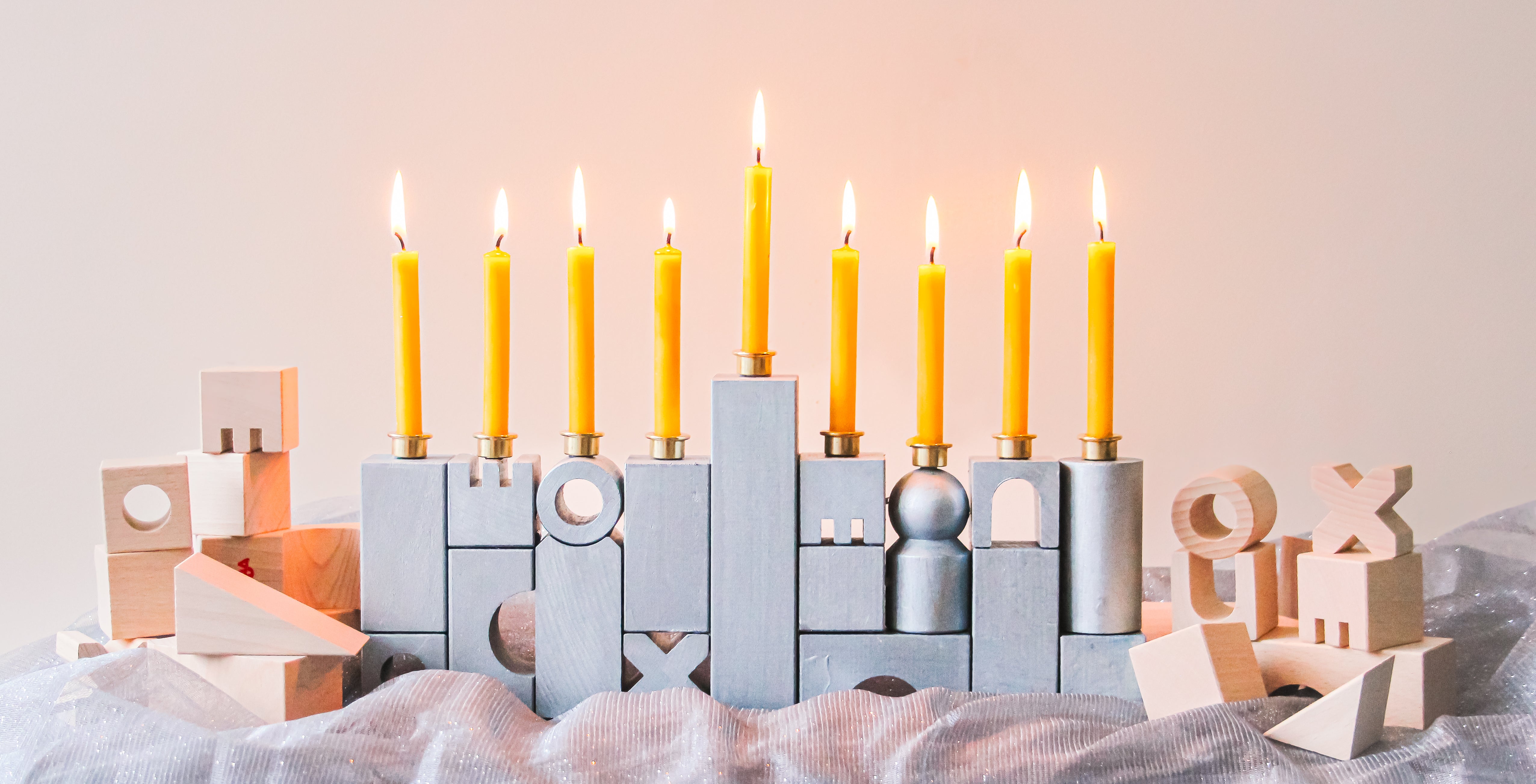 A DIY Menorah made of HABA Wooden Blocks is sitting on a table.