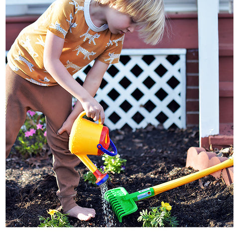 Boy watering garden with  Spielstabil watering can