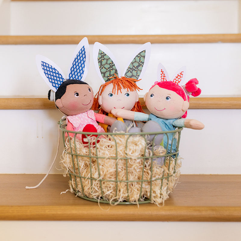 HABA dolls with bunny ears in a basket.