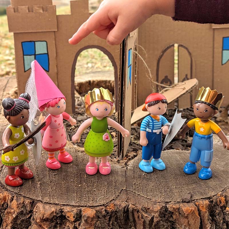 Little Friends dolls are in front of a DIY castle.