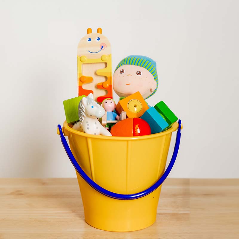 A rainbow bucket filled with HABA toys.