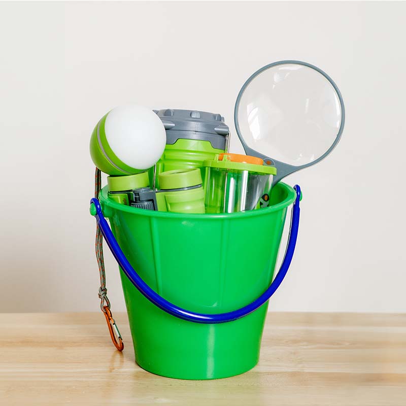 A green basket filled with adventure toys.