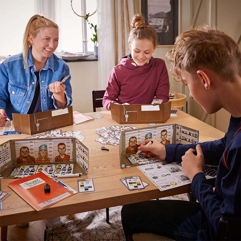 A family is playing a game together at a dining room table.