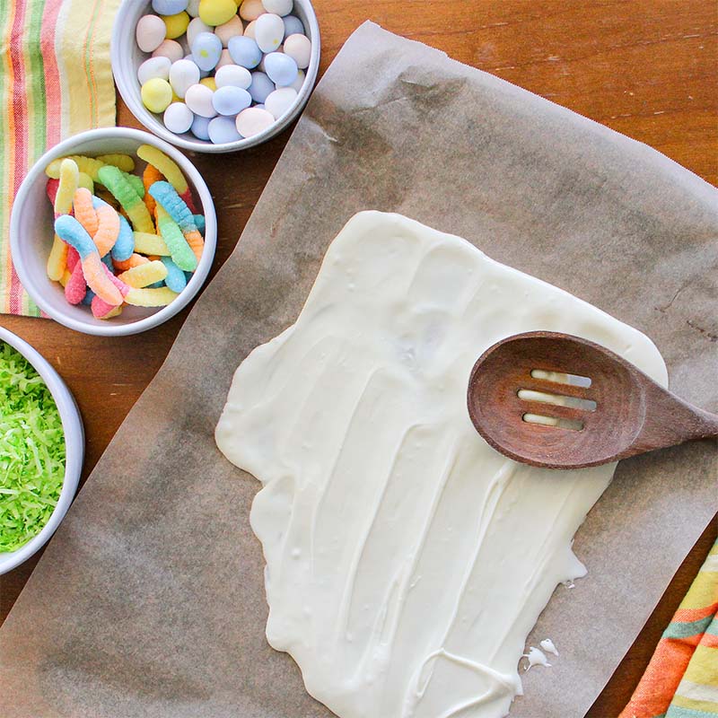 White chocolate being spread on a sheet.