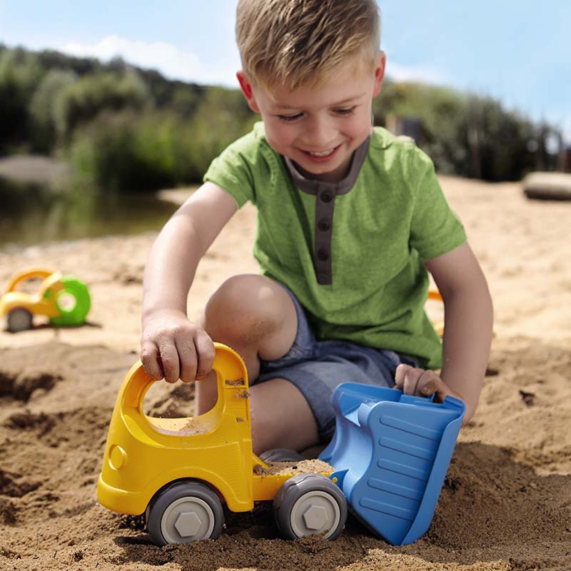 A kid is playing with a HABA sand toy.