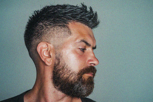 Good looking man with textured undercut haircut using matte clay paste