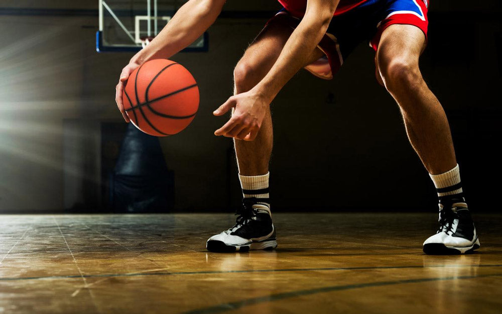 Uno sportivo mentre palleggia in palestra