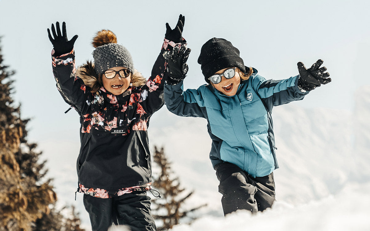 Due bambini con occhiali da sole Julbo giocano nella neve