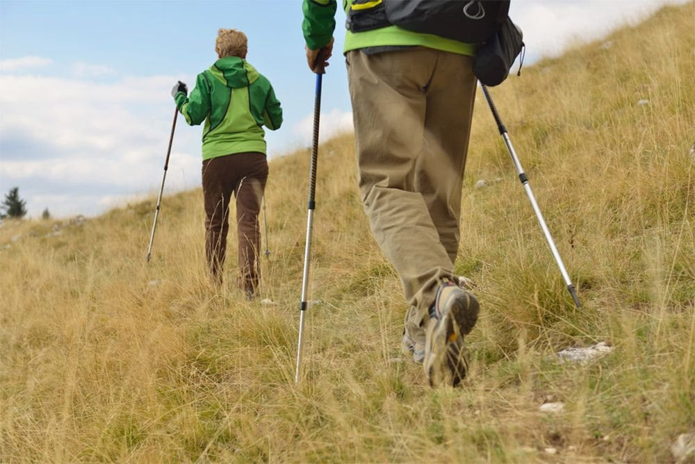 Escursionisti che camminano con bastoncini da trekking
