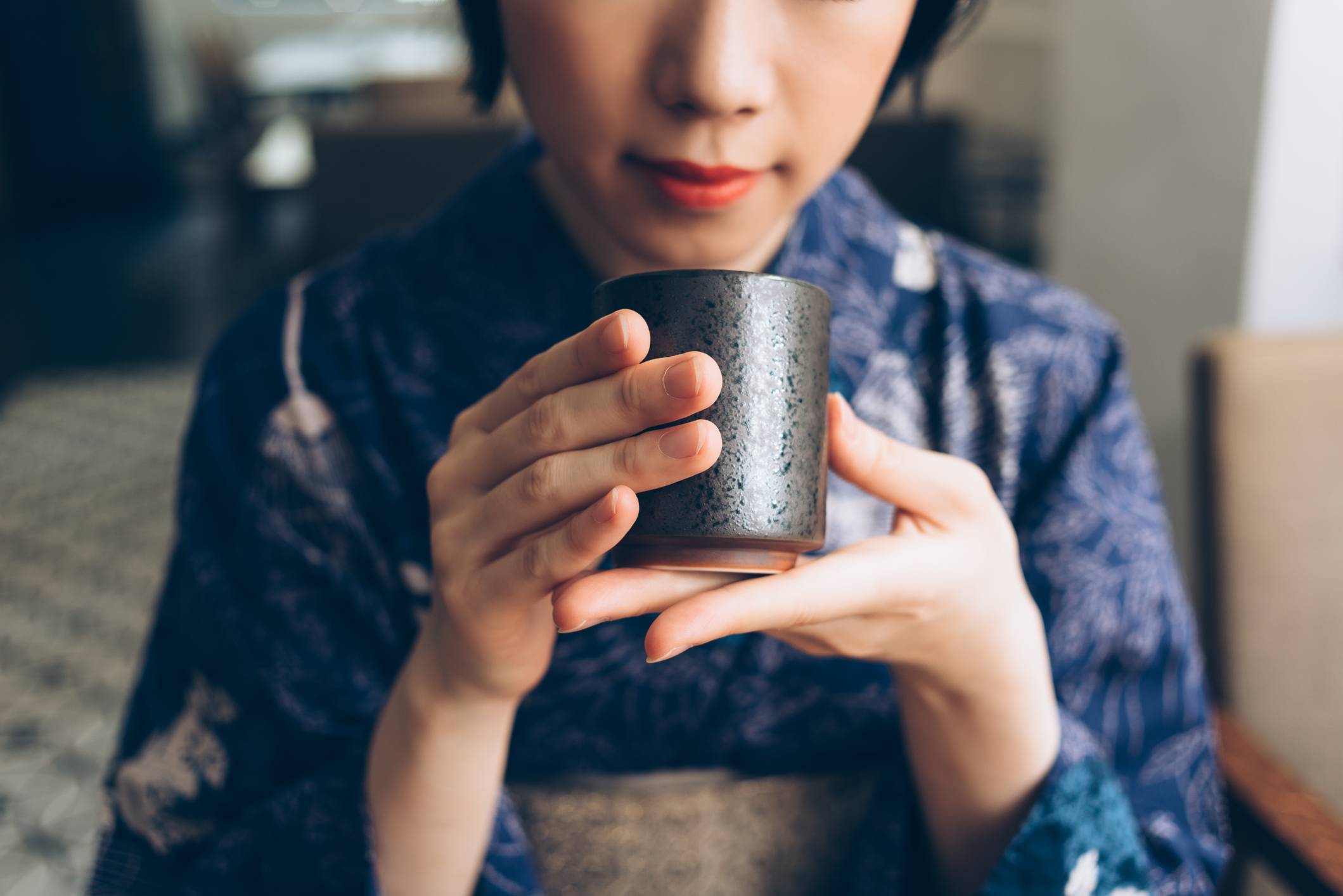 Japanese woman holding a Yunomi tea cup