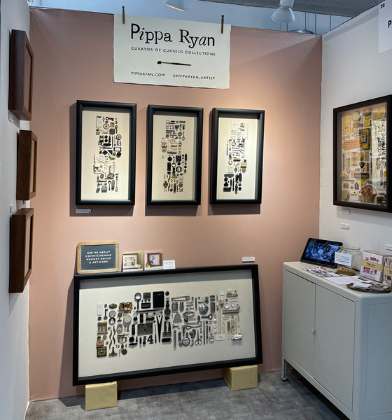 image of my stand at made london, it has a pink background and hanging are lots of my vintage object artworks