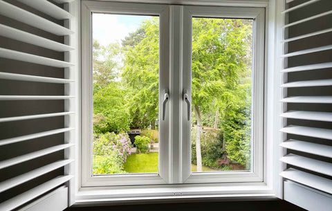 white wooden window shutters open looking on to garden