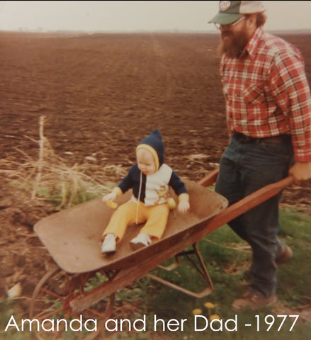 Amanda getting a ride in a wheelbarrow from her dad