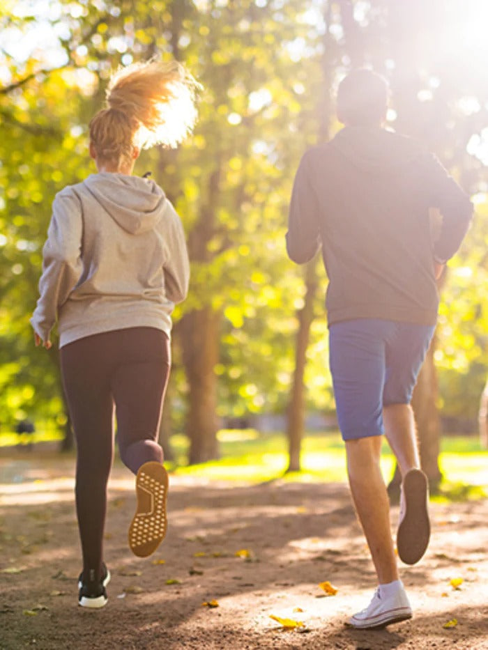 Twee mensen joggen in het park, gezien vanaf de achterkant.