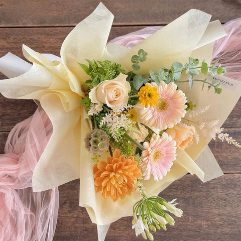 small bouquet wrapped by floral tissue paper