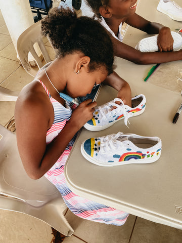 Girl working on decorating her white tennis shoes
