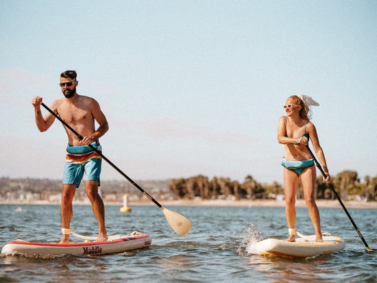 Man and woman paddle boarding athletically