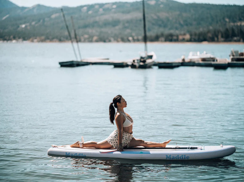 girl doing the splits on a paddle board