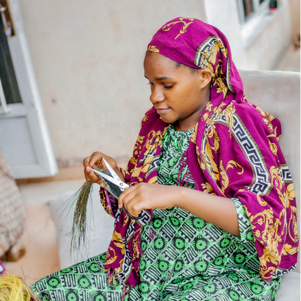 A Rwandan Woman Weaving a Basket by Hand