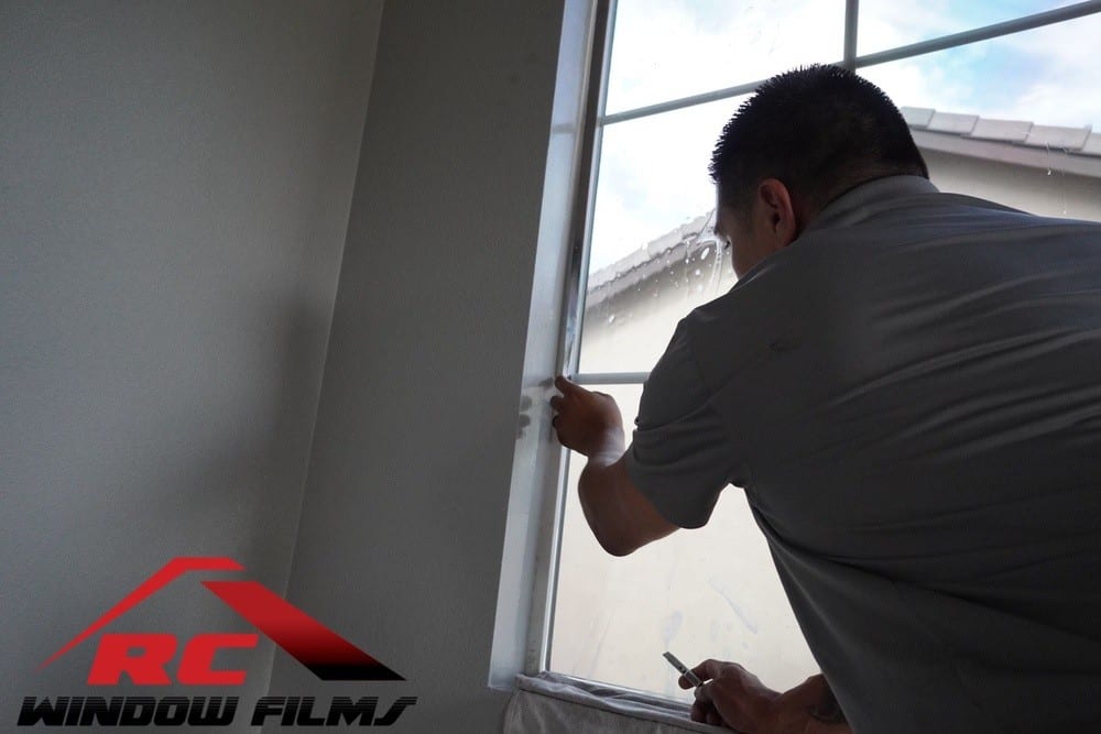 cutting home window tint to size during a home window tinting installation in menifee ca