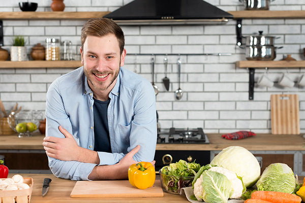 Mann mit Gemüse in Küche