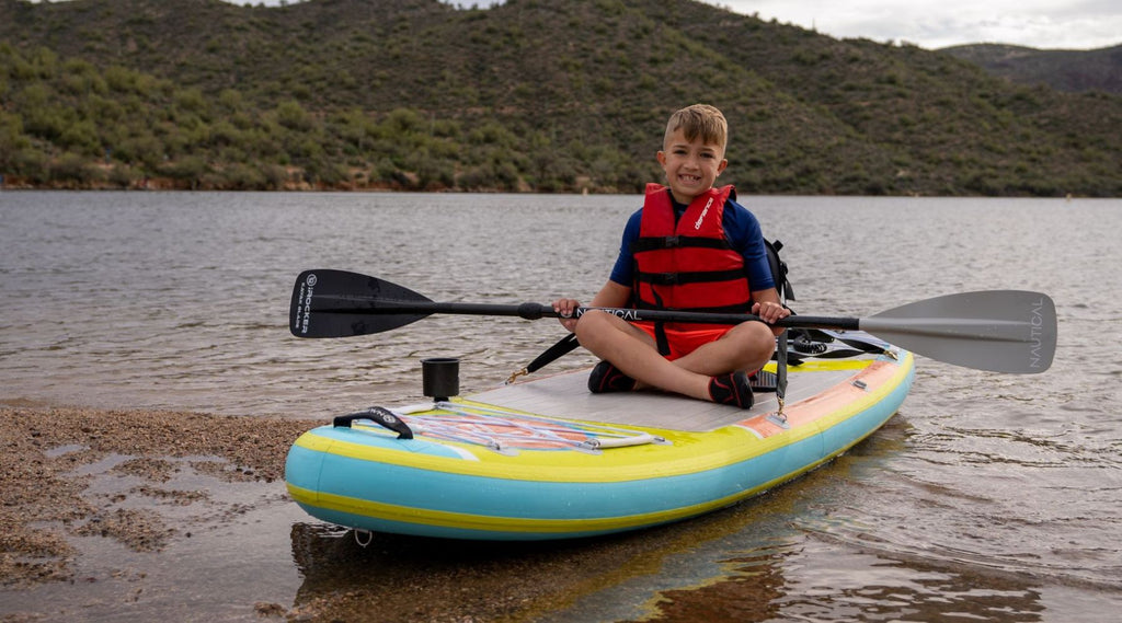 child kayaking on a paddle board