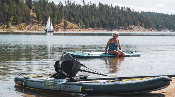 Elderly woman sitting on a paddle board