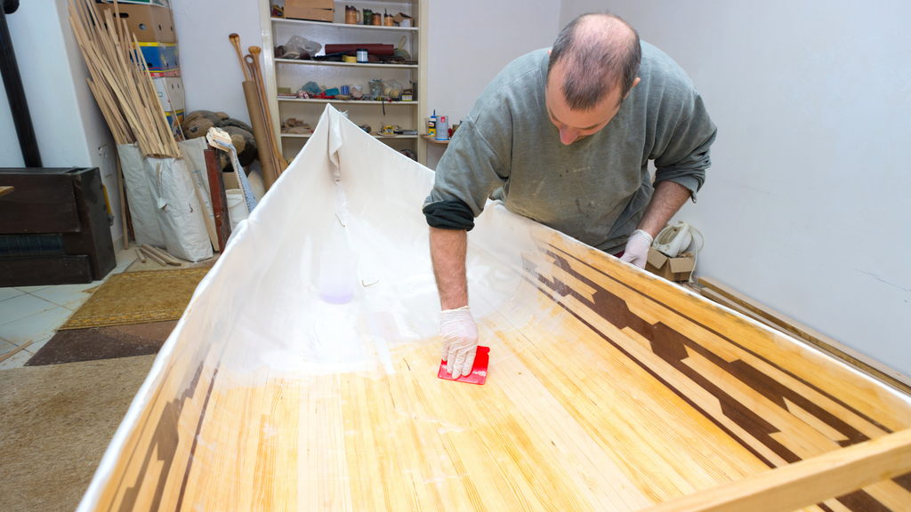 Ein Holzboot wird Glasfaser und Epoxidharz beschichtet