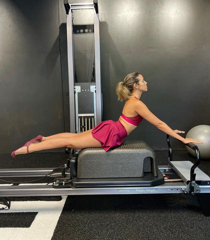 woman stretching on pilates reformer