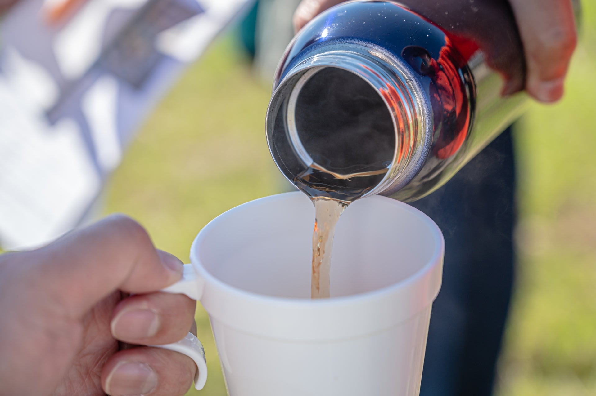 水筒からマグカップにコーヒーを入れる様子