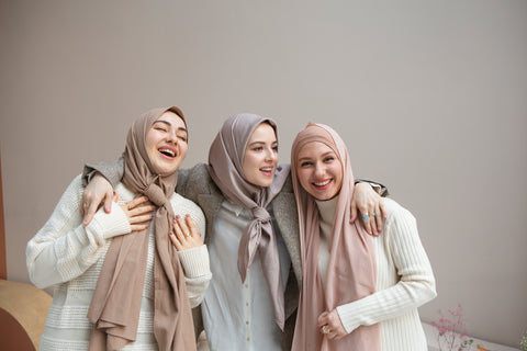 Three girls wearing modest wear and smiling