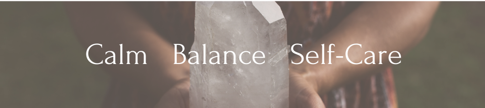 A woman stands holding a large crystal. The words 'Shop by Intention Calm Self-Care Healing Stones' appear over top