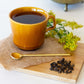 Brown mug of Nepalese Gold Black Tea with thin gold spoon