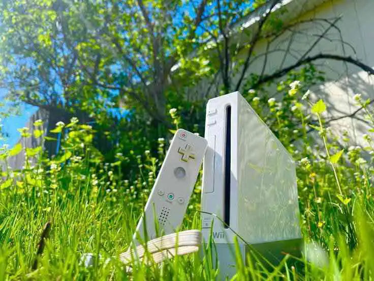 A Wii console sitting outside on the grass.