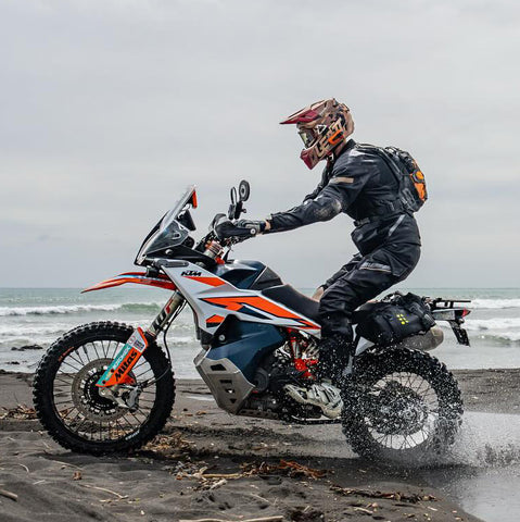 Motorcyclist riding his motorbike on a beach, wearing a Kriega Trail9 backpack