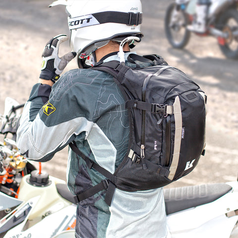 Rear view of a dirtbiker wearing a helmet and a Kriega R15 backpack