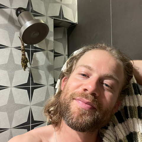 man in shower using filtered showerhead for hair loss prevention