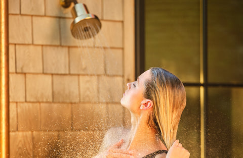 woman using outdoor showerhead water filter