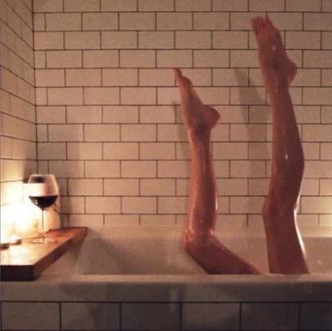 person in bathtub with only two legs in air visible