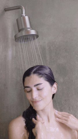gif of woman using a filtered showerhead (how to stop excessive hair shedding)