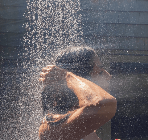 woman using filtered shower head for hard water