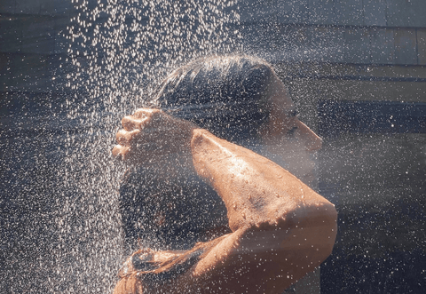 how to increase water pressure in shower, woman with rainfall shower over her