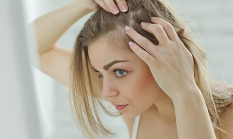 woman looking at hairline in mirror, should have used more fine hair products