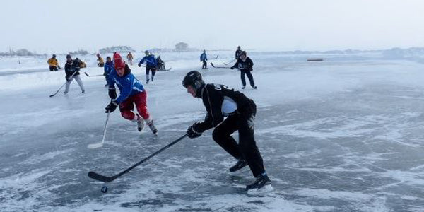 Hockey players on the ice at the Labatt Blue Upper Peninsula Pond Hockey Tournament.