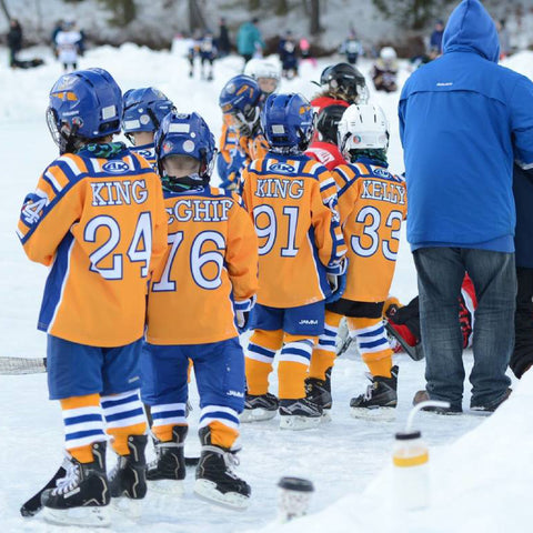 Image of kids playing hockey at the Youth Pond Hockey Festival for the Laura Foundation.