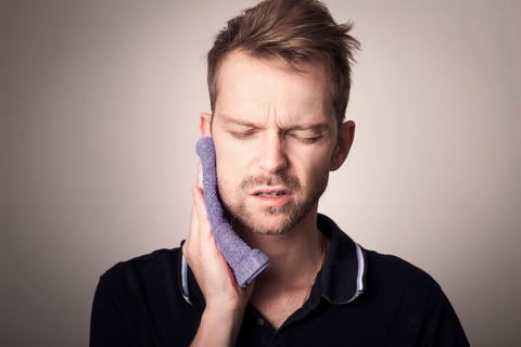 A person using a compress for toothache